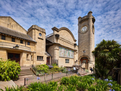 horniman exterior with blue skies and garden foliage, centred on clocktower