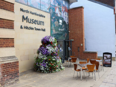 north hertfordshire museum modern yellow brick exterior with flowers on stand