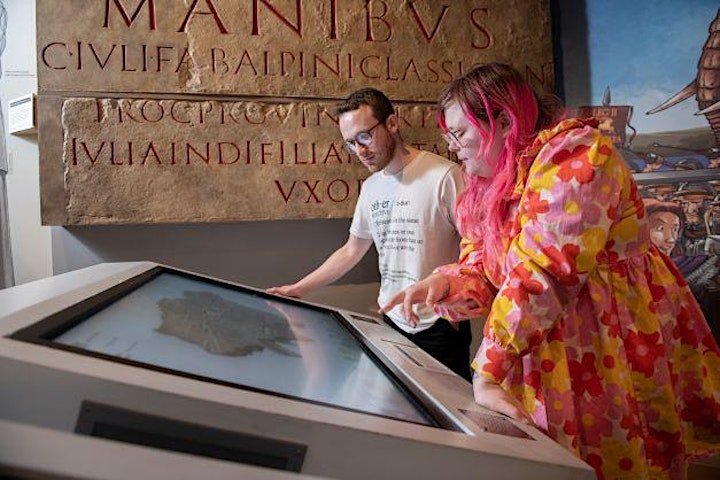 Two people looking at an interactive screen in a museum